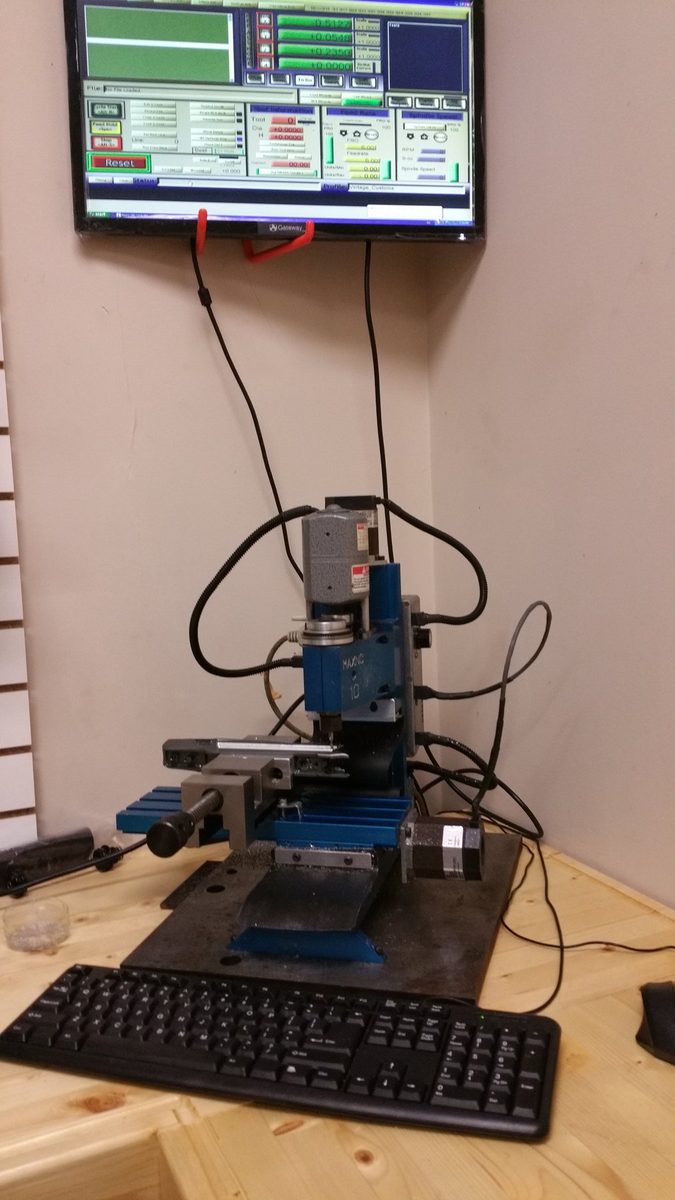 The MaxNC 10 benchtop CNC mill set up beneath its Mach3 control screen.