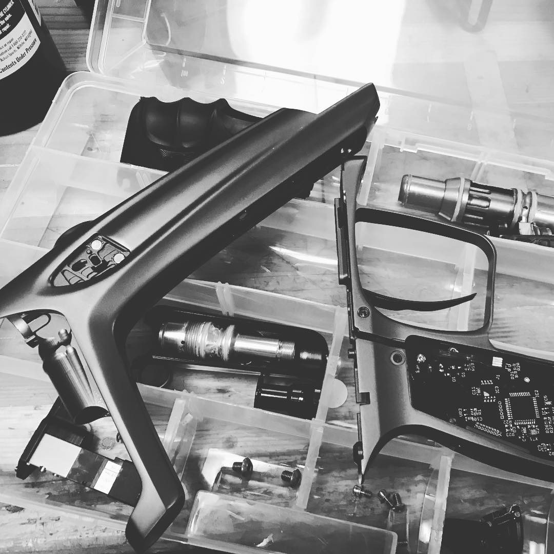 A DLX Luxe torn down across a parts organizer: body, grip frame, bolt, regulator and circuit board.