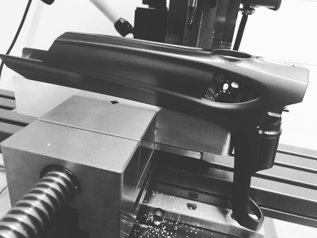 A DLX Luxe Ice body clamped in the mill vise, chips on the table beneath it.