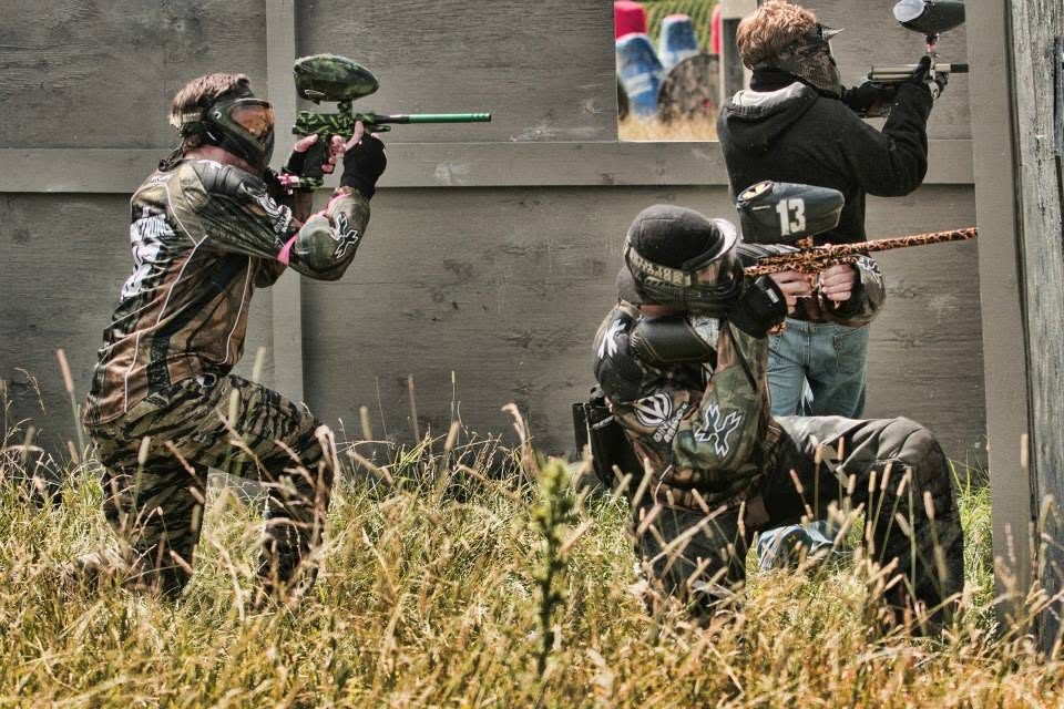 Tony, 13 on his loader, kneels at a plywood wall with teammates at the 2013 Vintage Big Game.